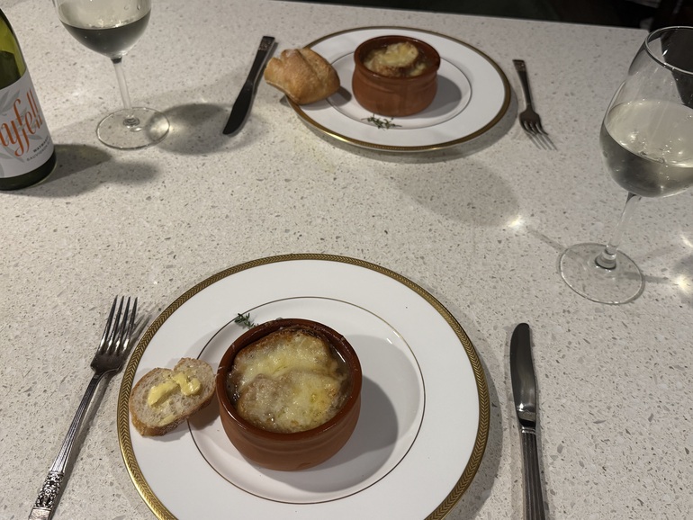 2 small bowls of French Onion Soup Dished up and ready to eat with a glass of South Australian White